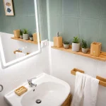 Lavandino bianco con specchio a LED illuminato e accessori in legno nel secondo bagno della casa vacanze La Dimora di Arianna a Cariati.
