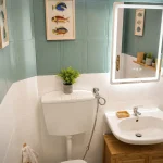 Sanitari e lavabo con specchio illuminato nel bagno di servizio della casa vacanze a Cariati Marina.