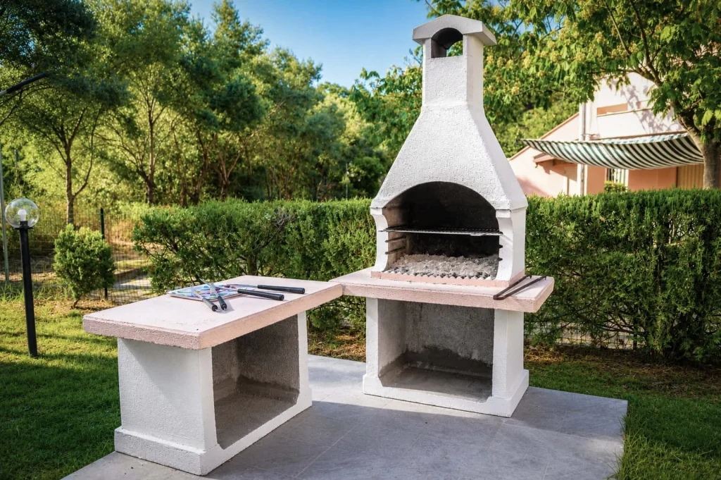 Grande barbecue in muratura esterno circondato dal giardino della casa vacanze La Dimora di Arianna a Cariati.