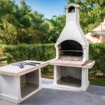 Grande barbecue in muratura esterno circondato dal giardino della casa vacanze La Dimora di Arianna a Cariati.