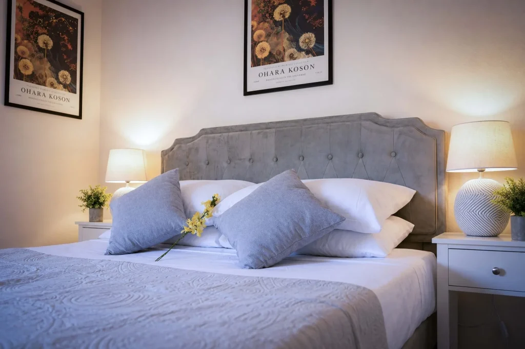 Letto matrimoniale king size allestito con biancheria bianca e cuscini grandi in una casa vacanze in Calabria.